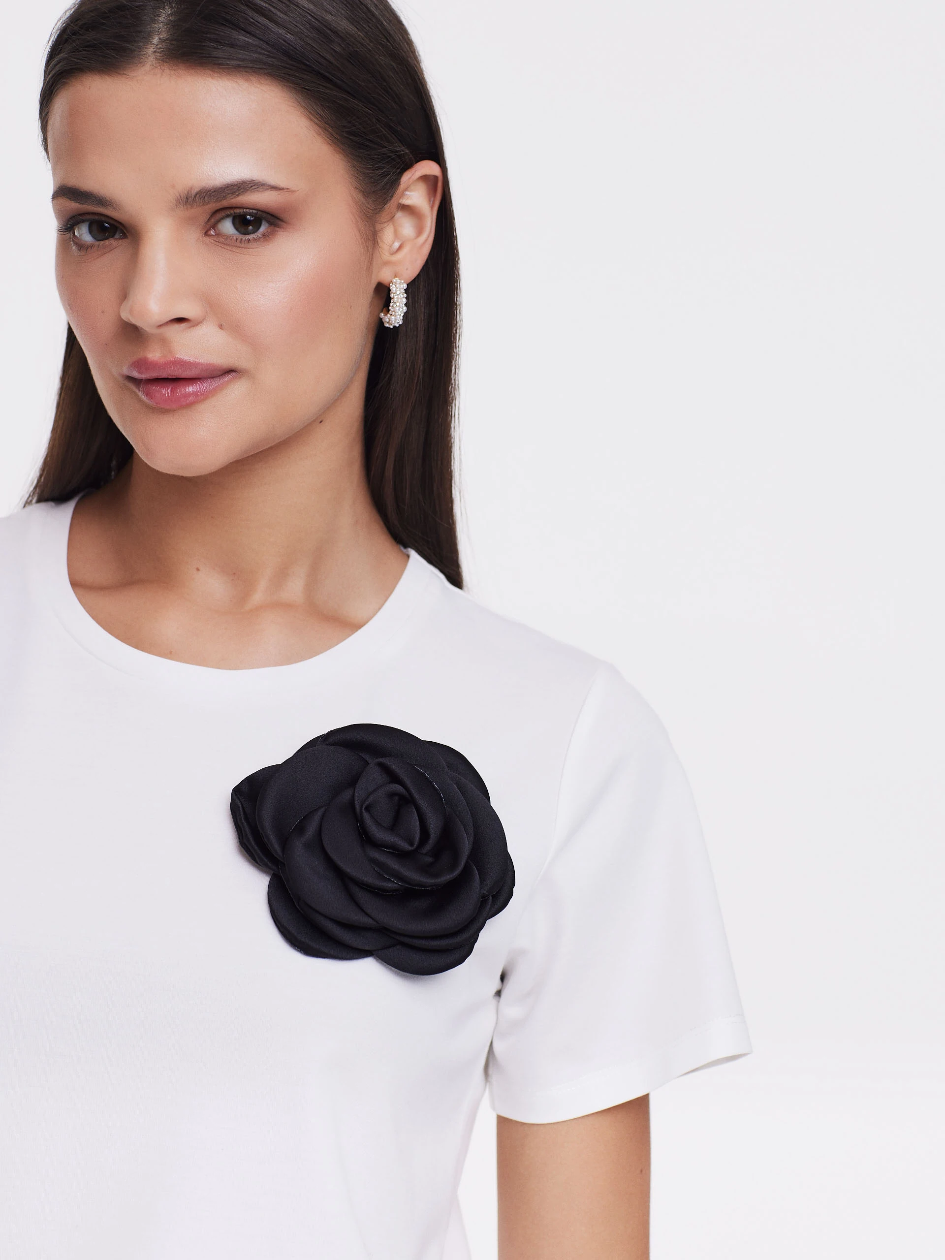 Biała bluzka z odpinaną ozdobą w kształcie róży