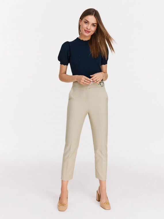 Beige high-waisted pants with clutch