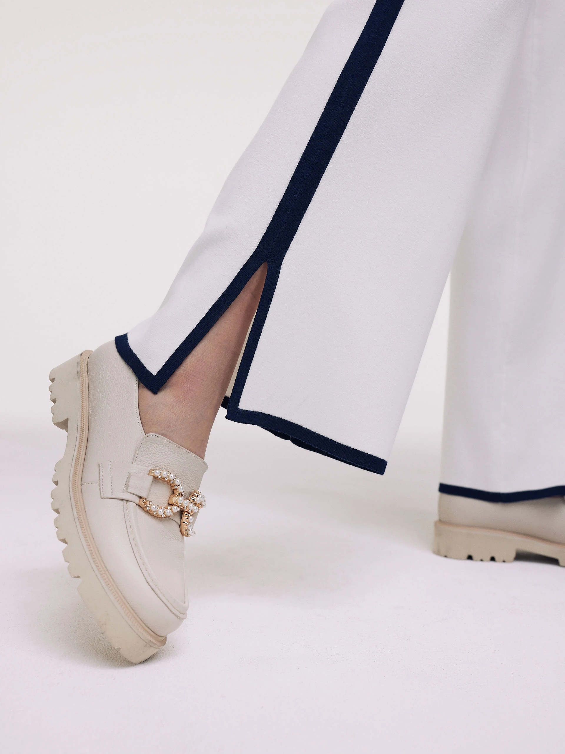 White pants with navy blue piping