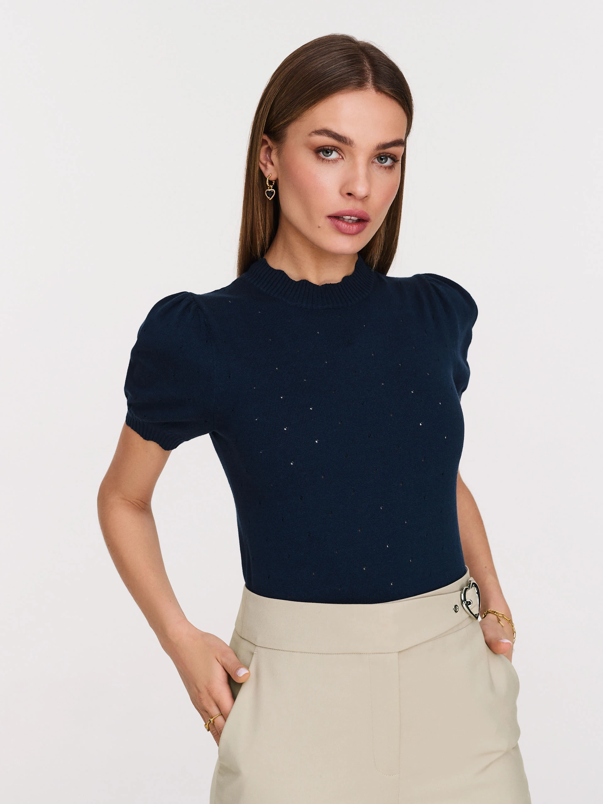 Beige high-waisted pants with clutch