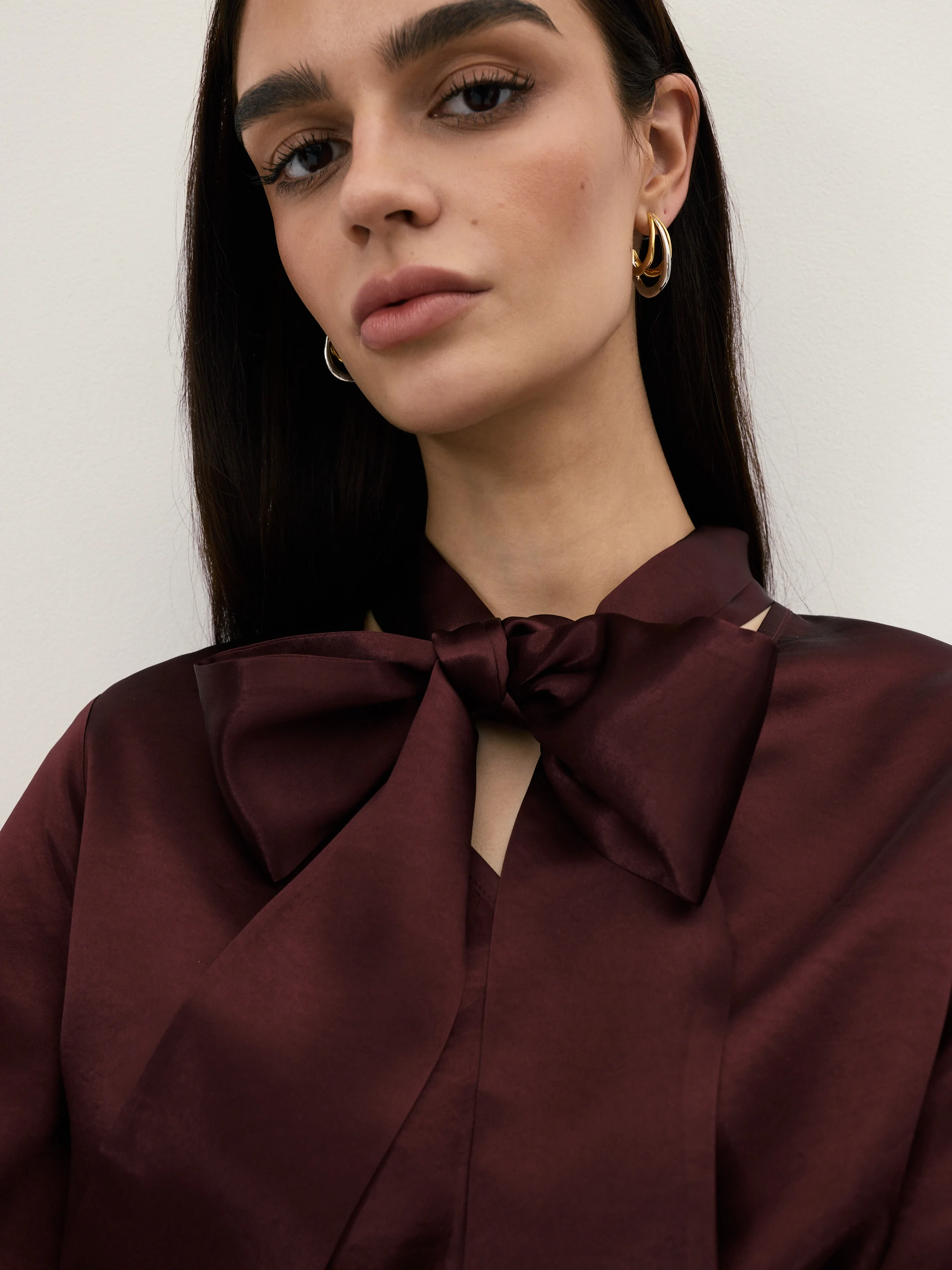 An elegant burgundy blouse with a sash