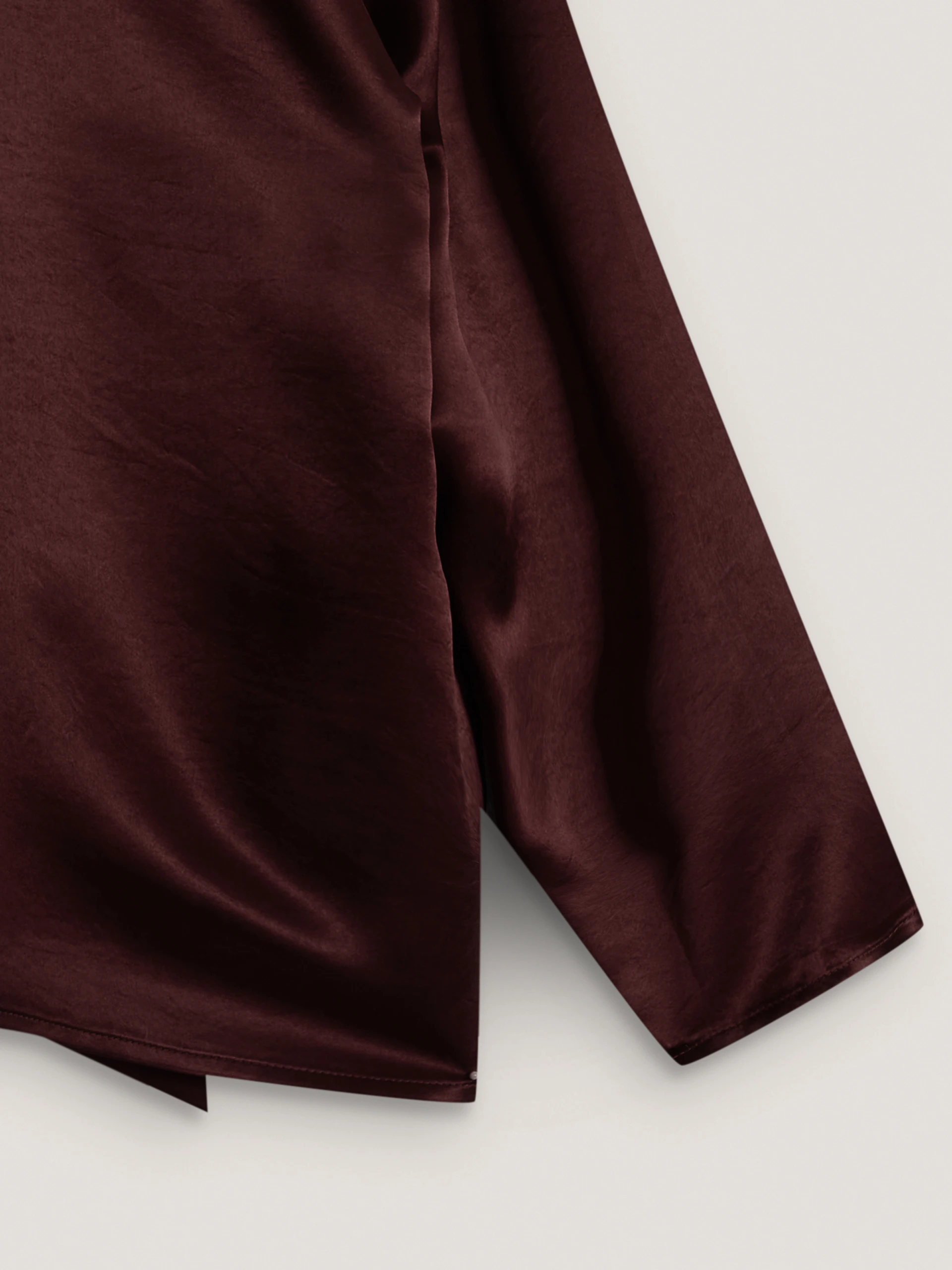 An elegant burgundy blouse with a sash