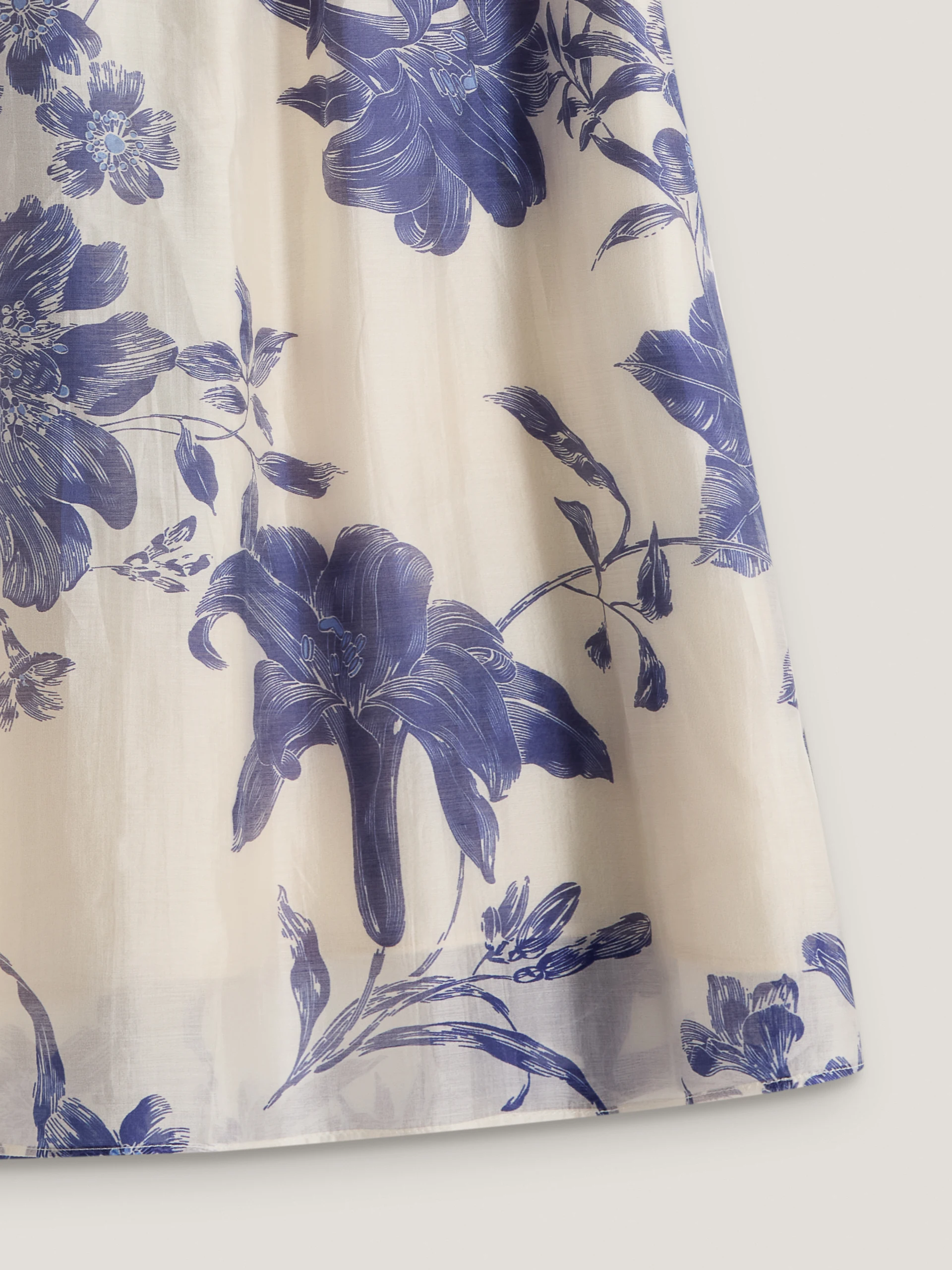 A cream-coloured, high-waisted skirt with navy blue floral print