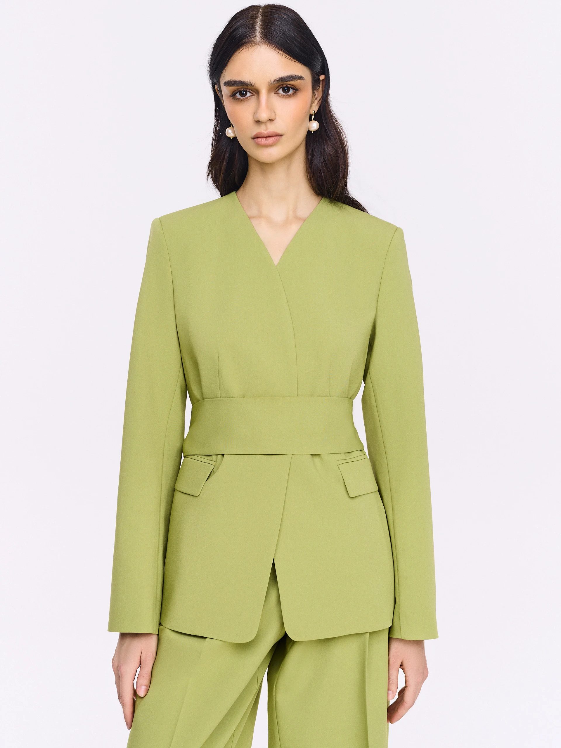 Green jacket with a sash and a jeweled button