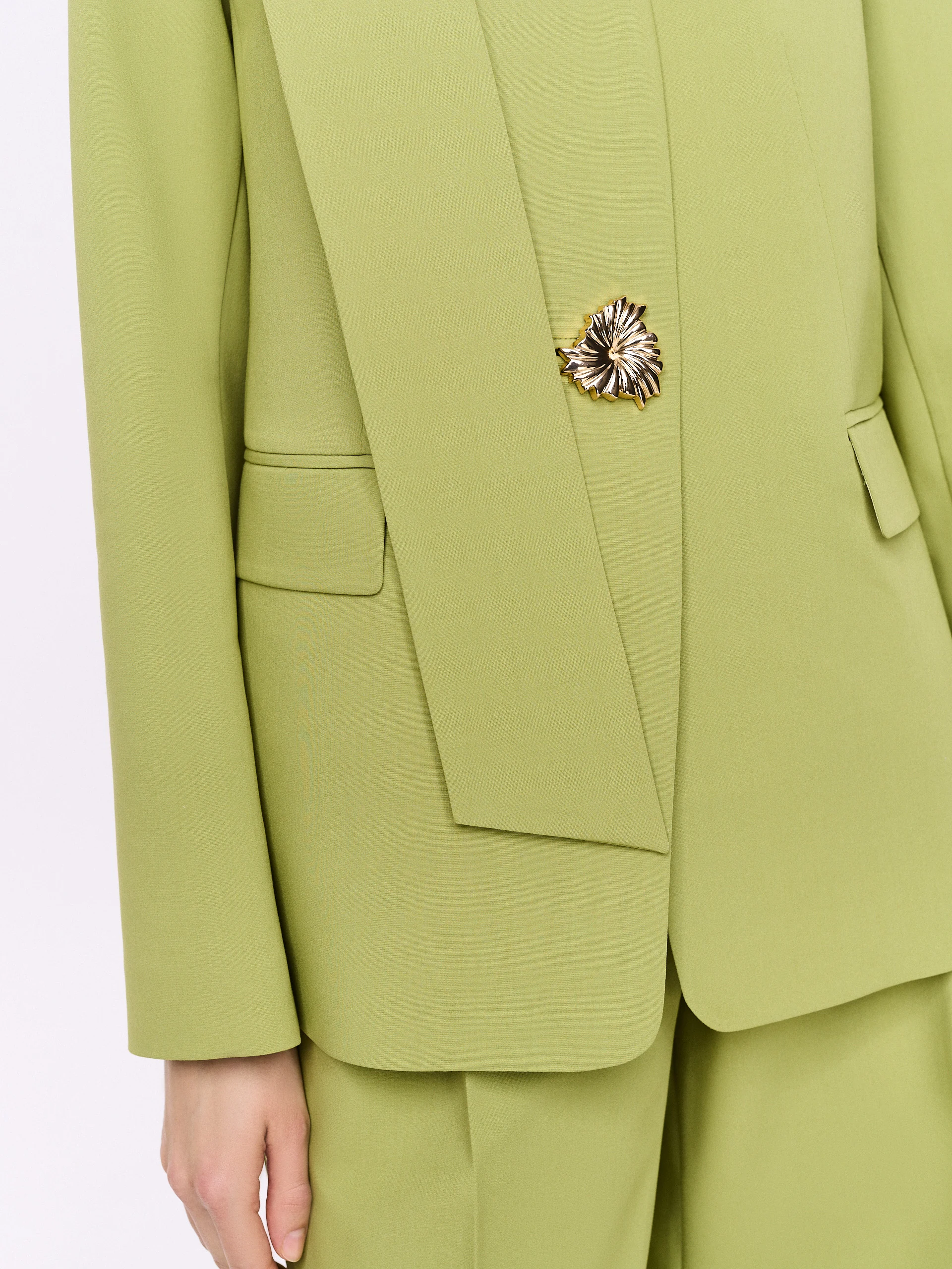 Green jacket with a sash and a jeweled button