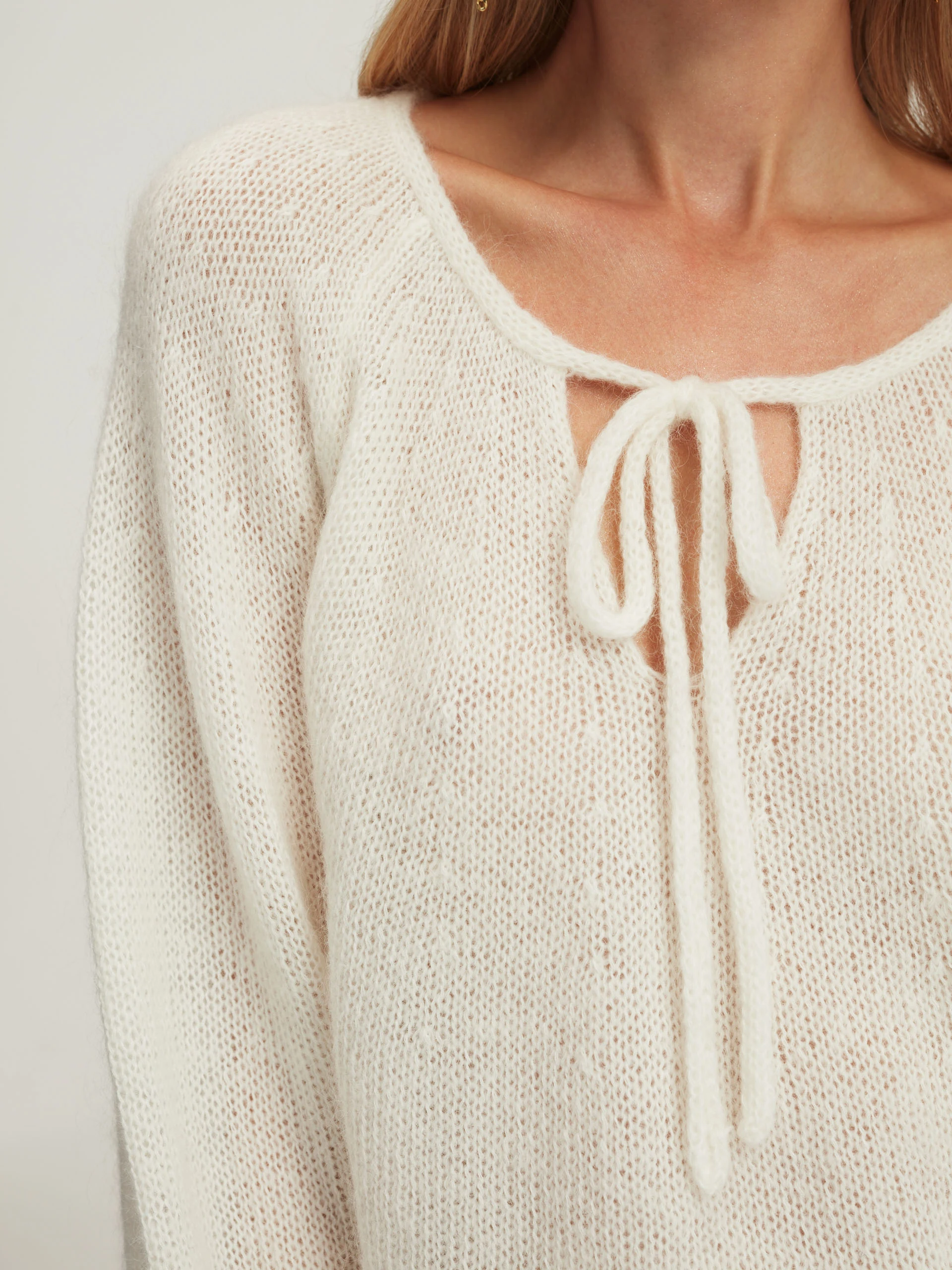 Loose white sweater with tied neckline