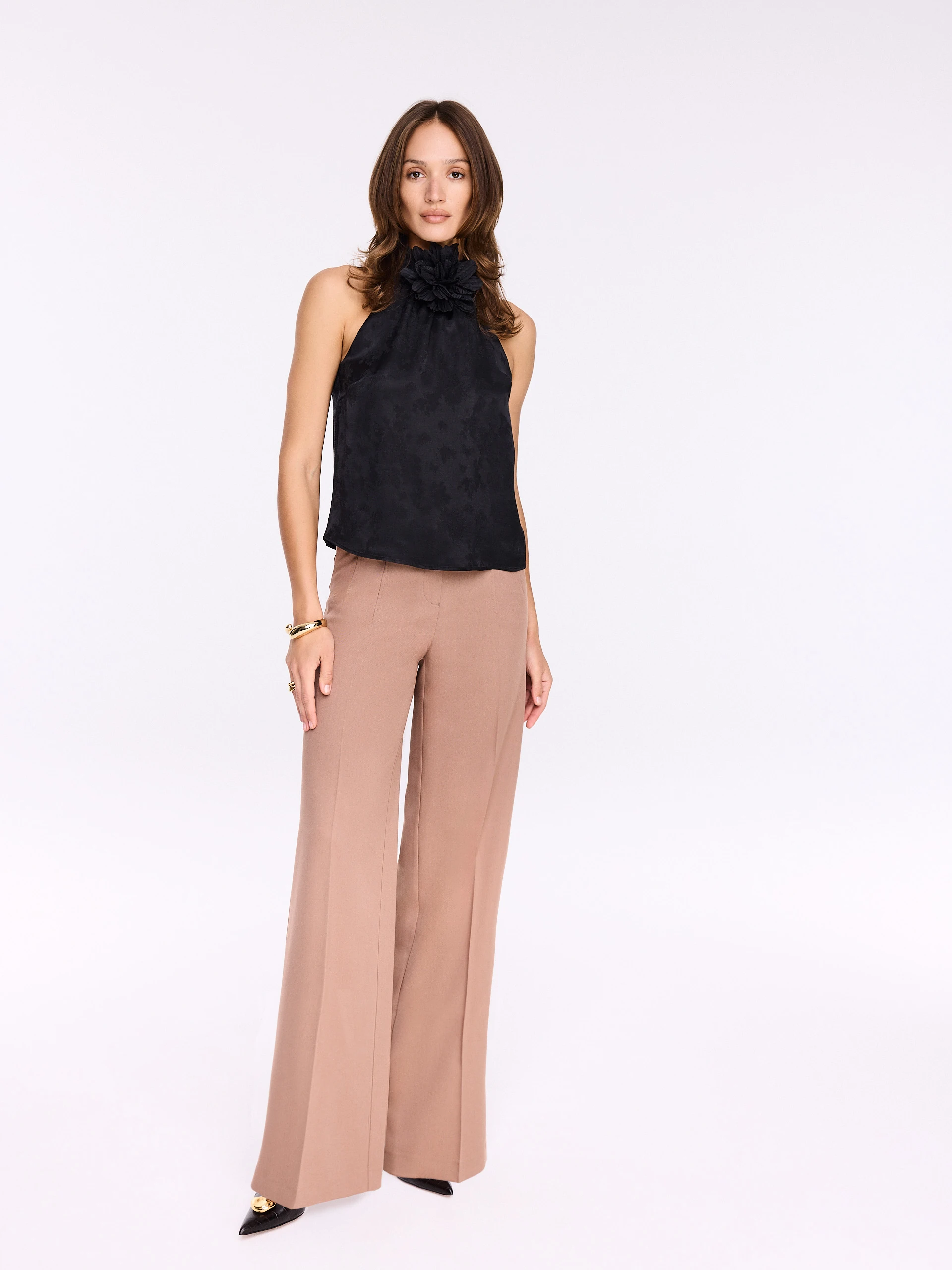 Black blouse with halter neckline and flower at the neck
