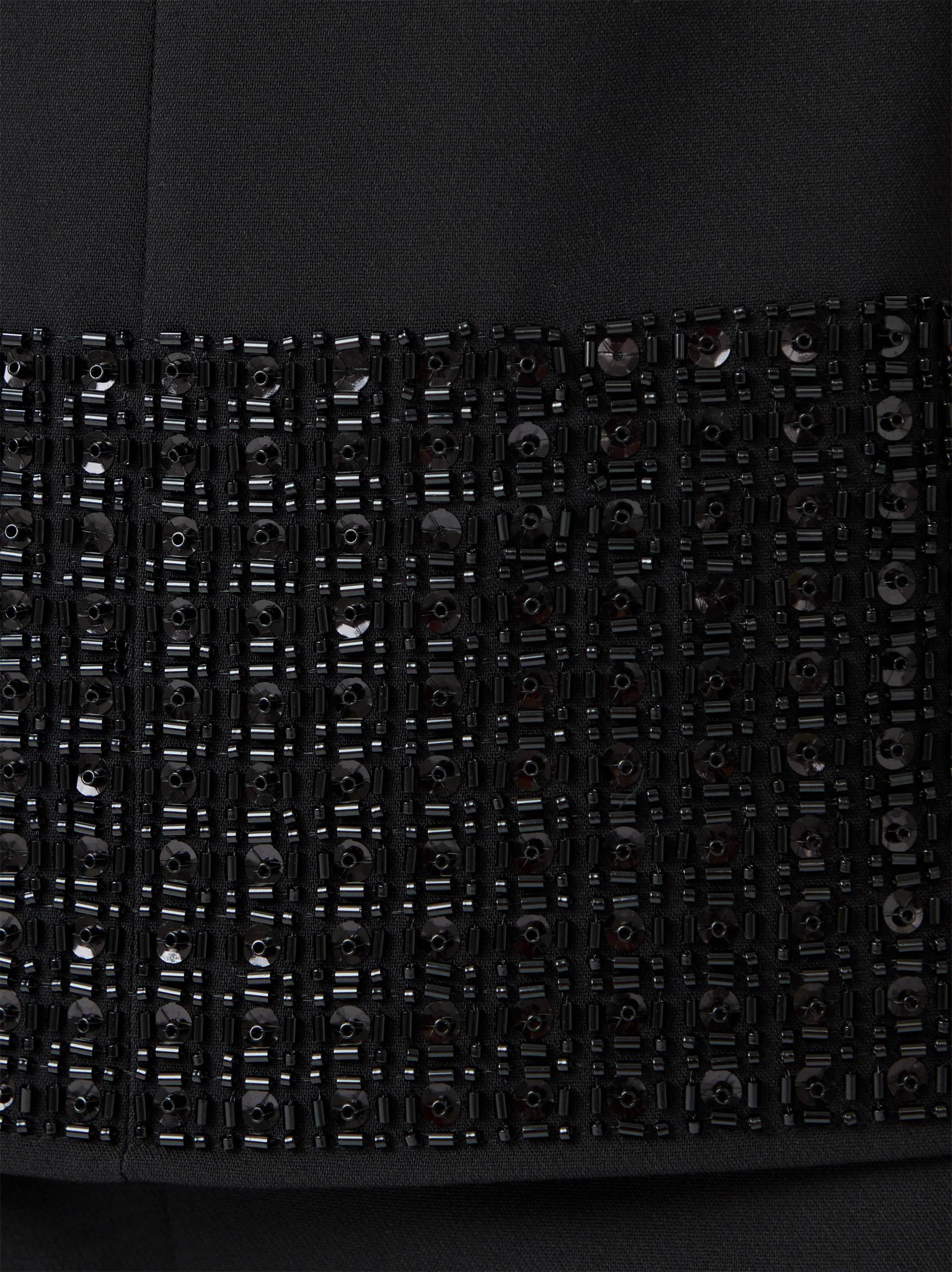 Black sleeveless blouse with decorative trim