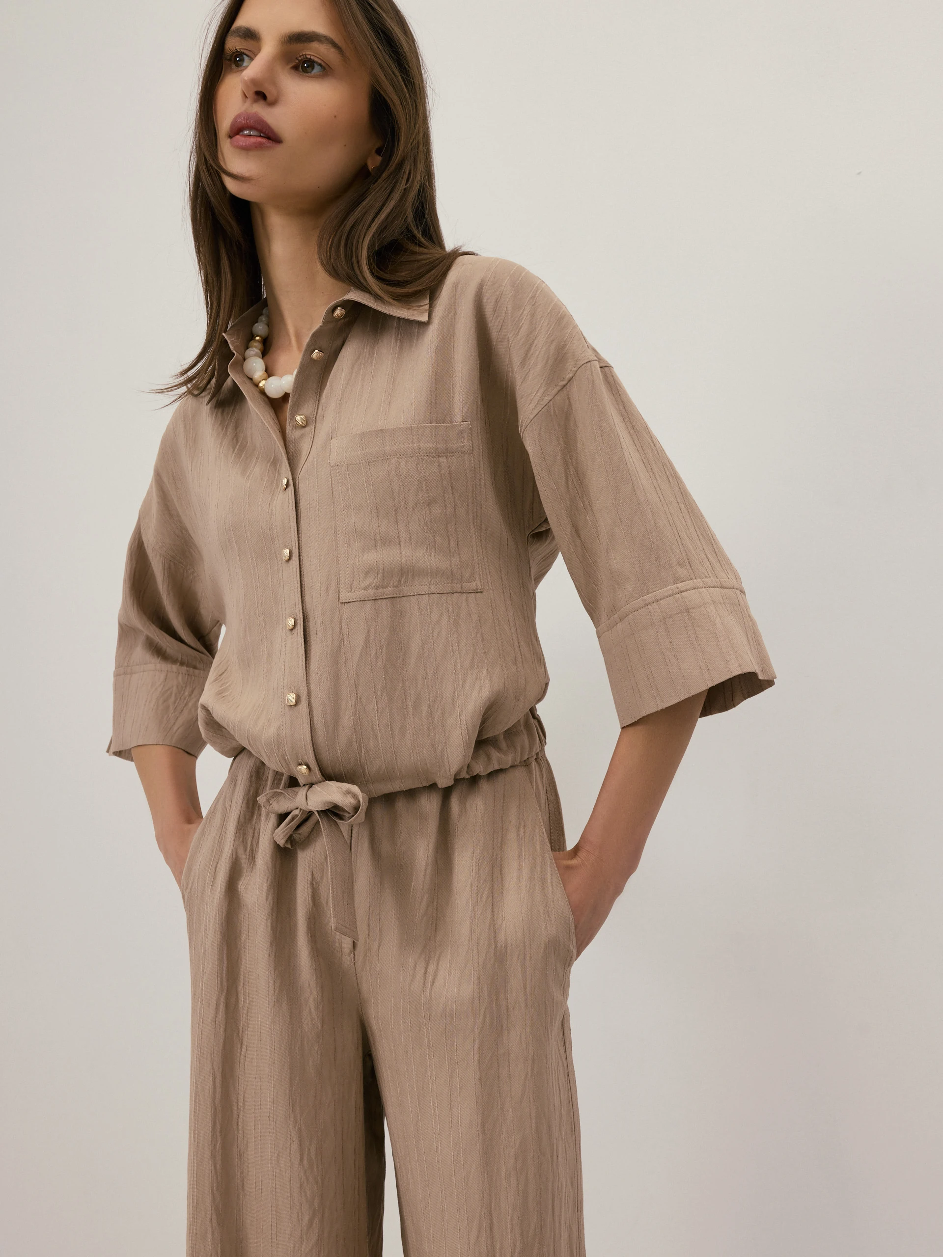 A beige short-sleeved shirt with a subtle ribbed pattern