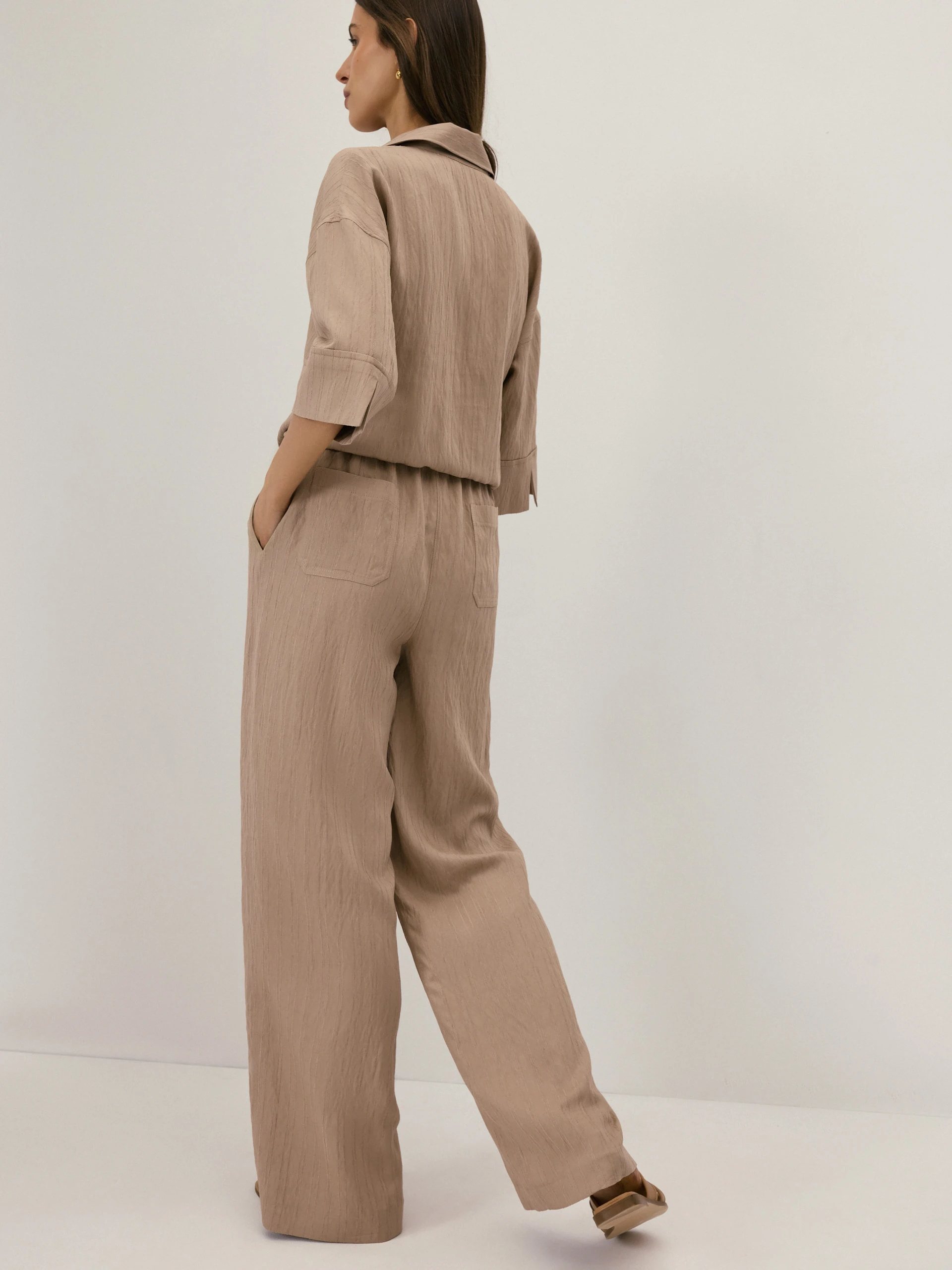 Beige high-waisted trousers with a subtle ribbed pattern