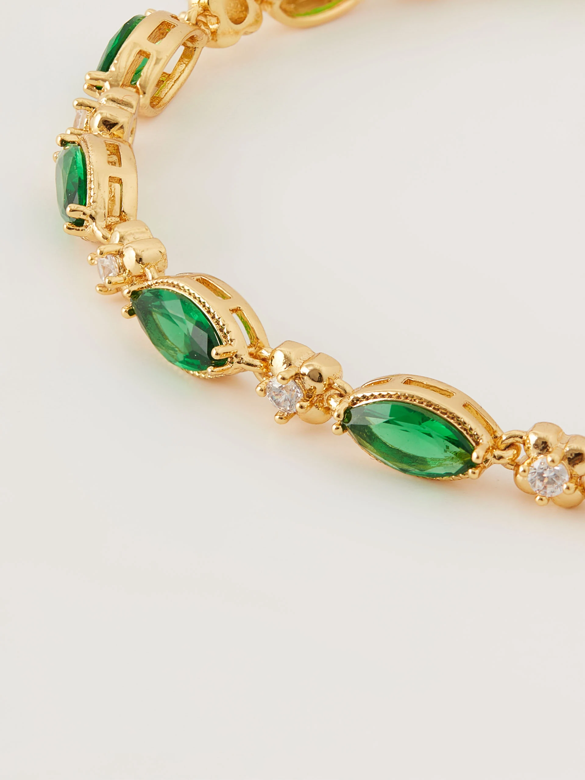 Bracelet in gold color with green crystals