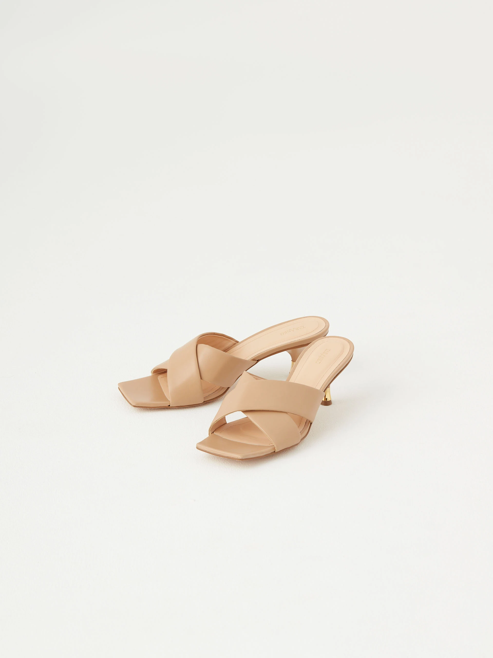 Beige flip-flops with decorative gold element on the heel
