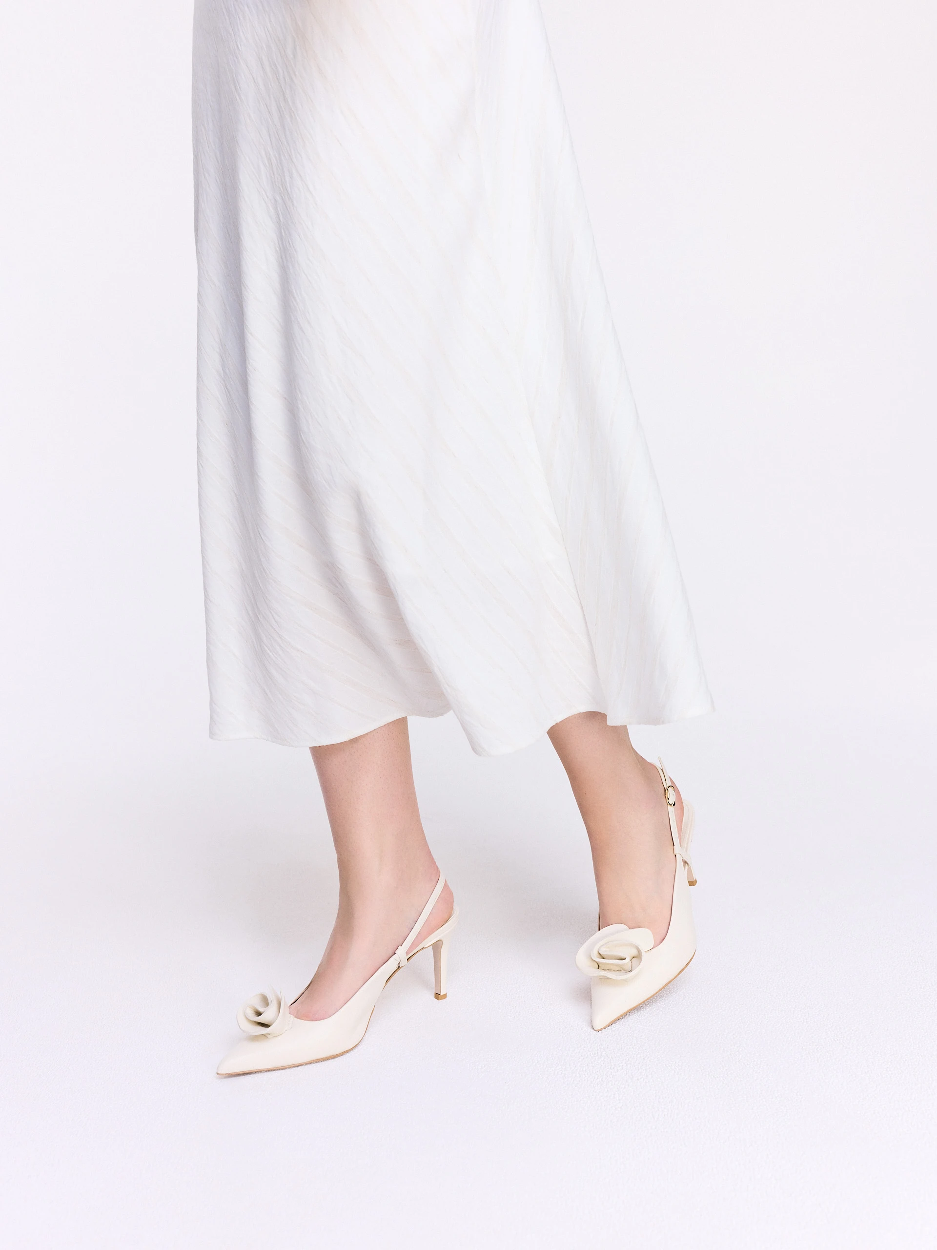 Cream-colored leather pumps with a flower