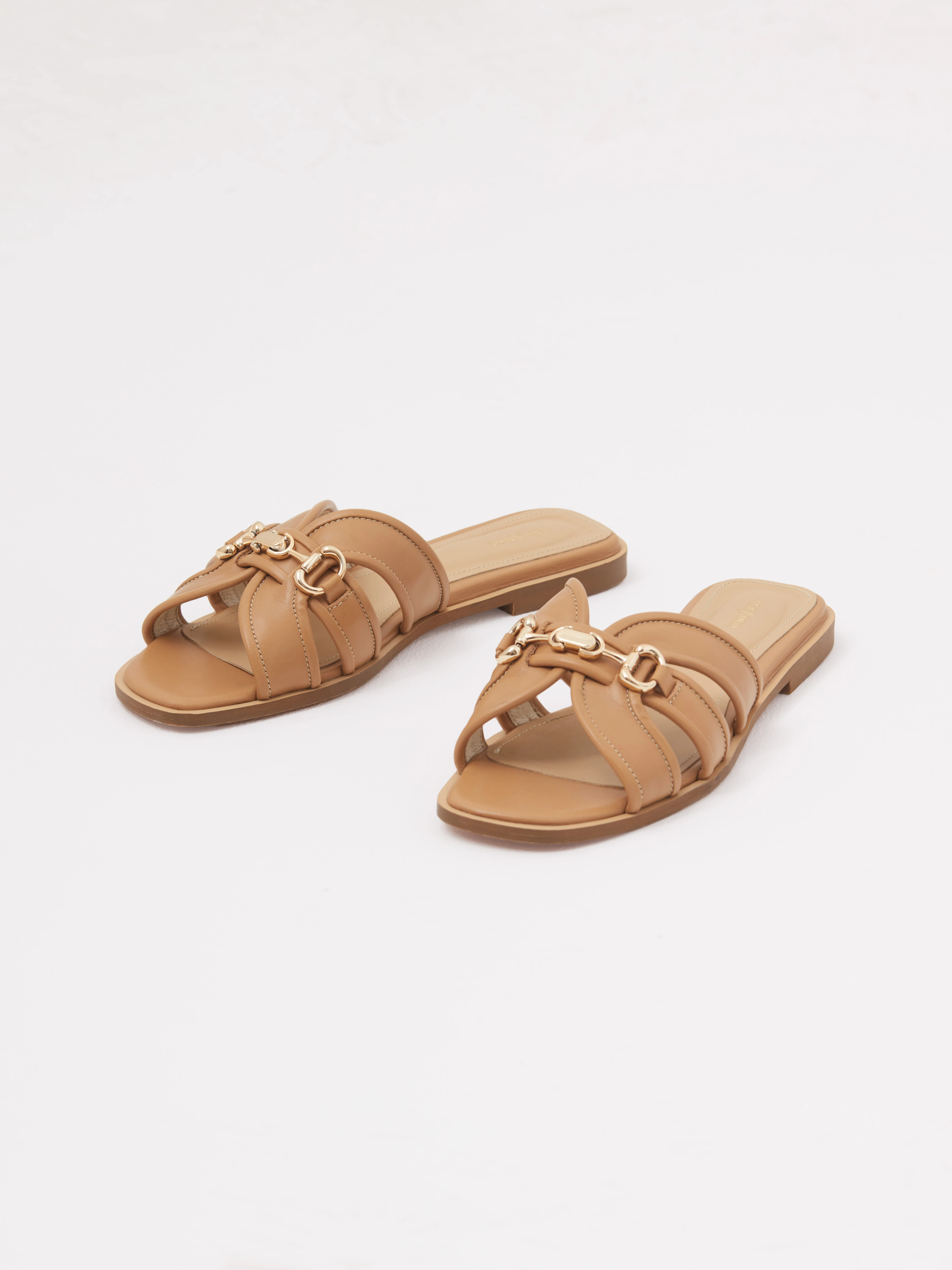 Caramel-colored leather flip-flops with a decorative buckle