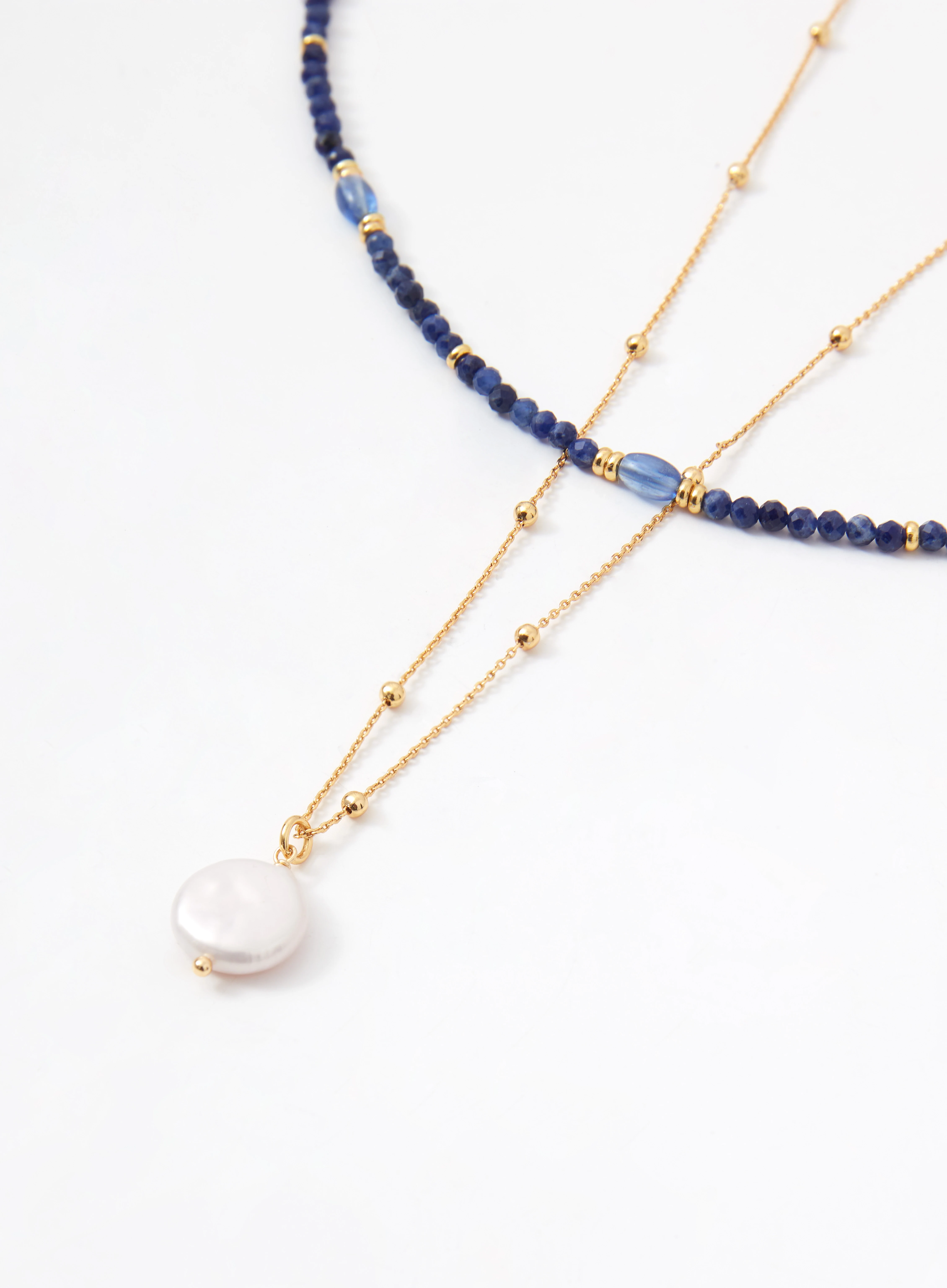 A set of two beaded necklaces with gold-colored pendants