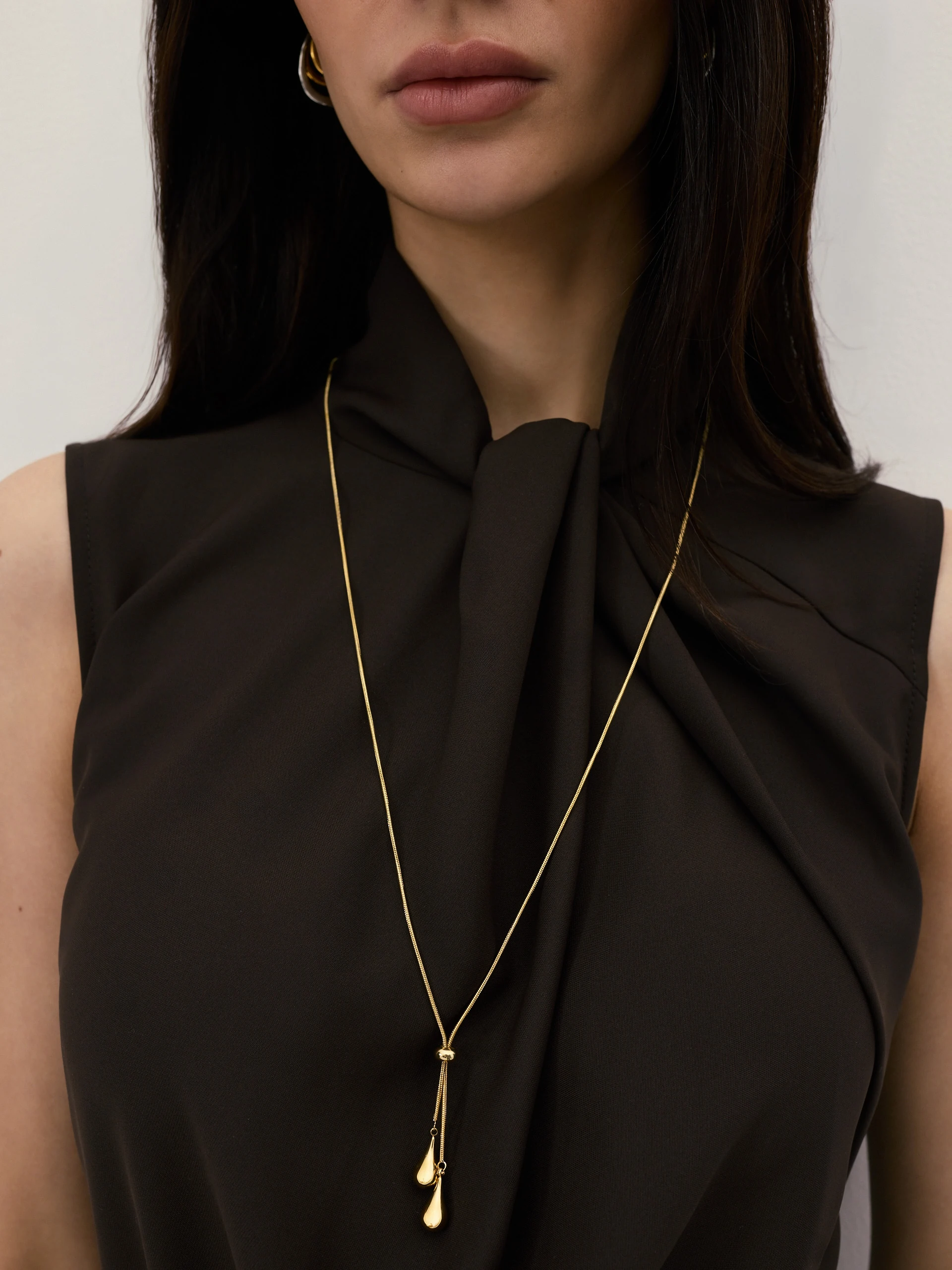 A long, gold-plated necklace with a bow