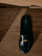 Black leather moccasins with gold buckles