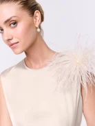 A cream-colored brooch made of bird feathers