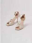 Cream-colored heeled sandals with pearl detailing