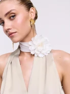 A cream-colored scarf-style necklace with a flower