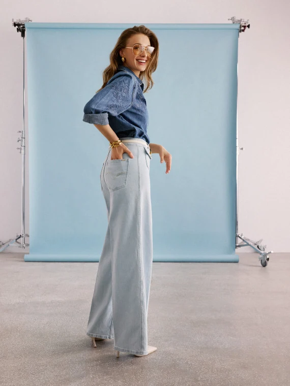 Light-colored wide-leg jeans with decorative buttons
