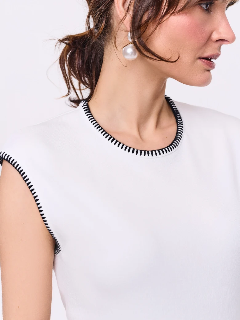 White sleeveless blouse with decorative trim