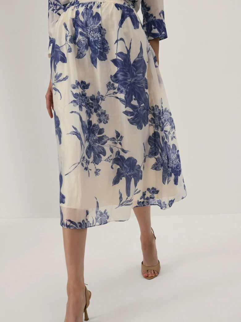 A cream-coloured, high-waisted skirt with navy blue floral print