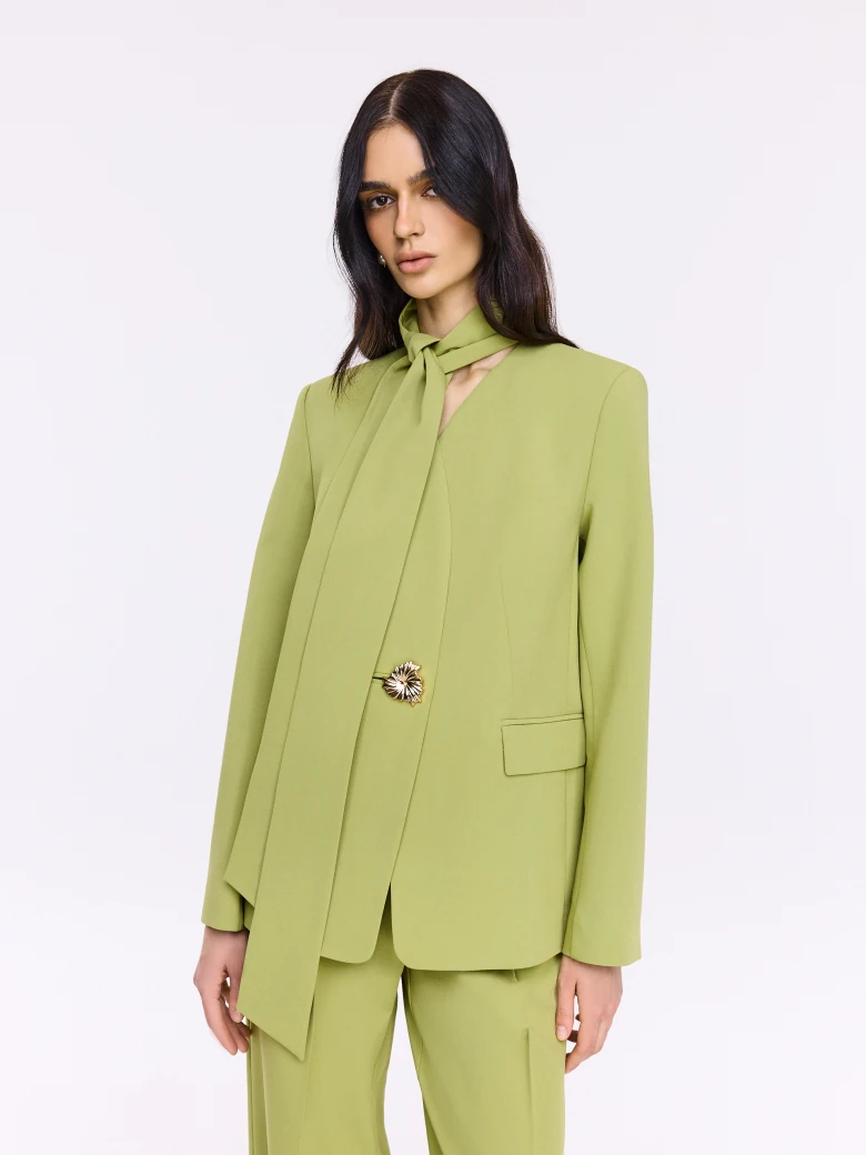 Green jacket with a sash and a jeweled button