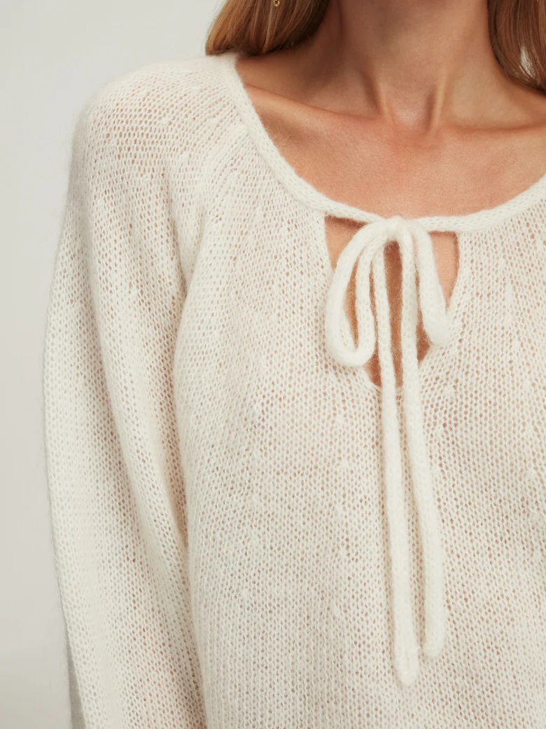 Loose white sweater with tied neckline