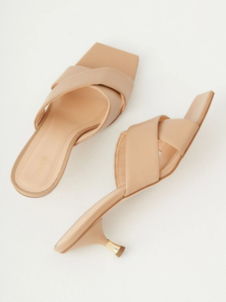 Beige flip-flops with decorative gold element on the heel