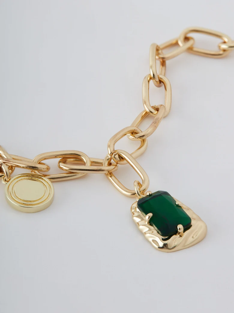 Gold colored necklace with green zirconia