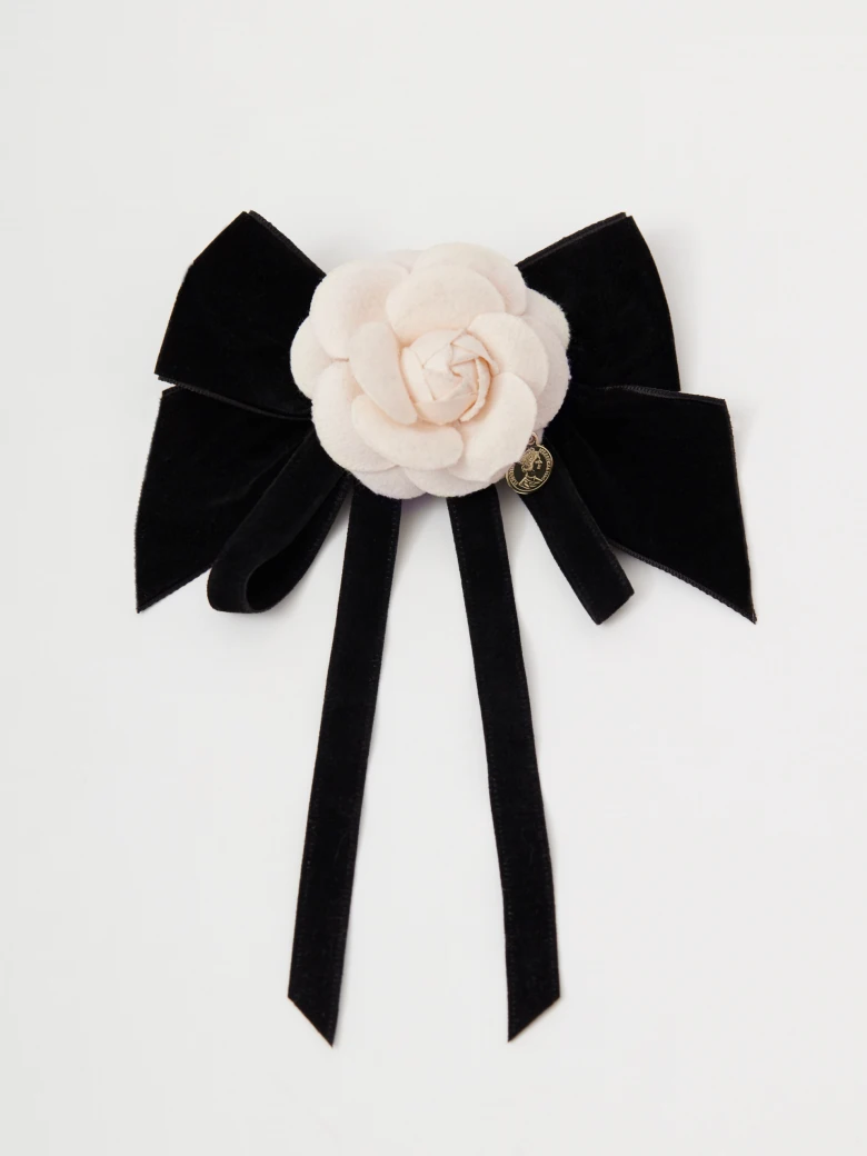 Brooch in the shape of a bow with a flower