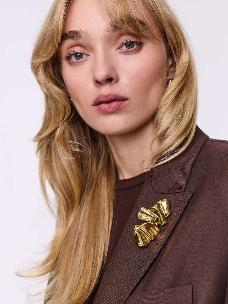 Gold-colored brooch with an irregular shape