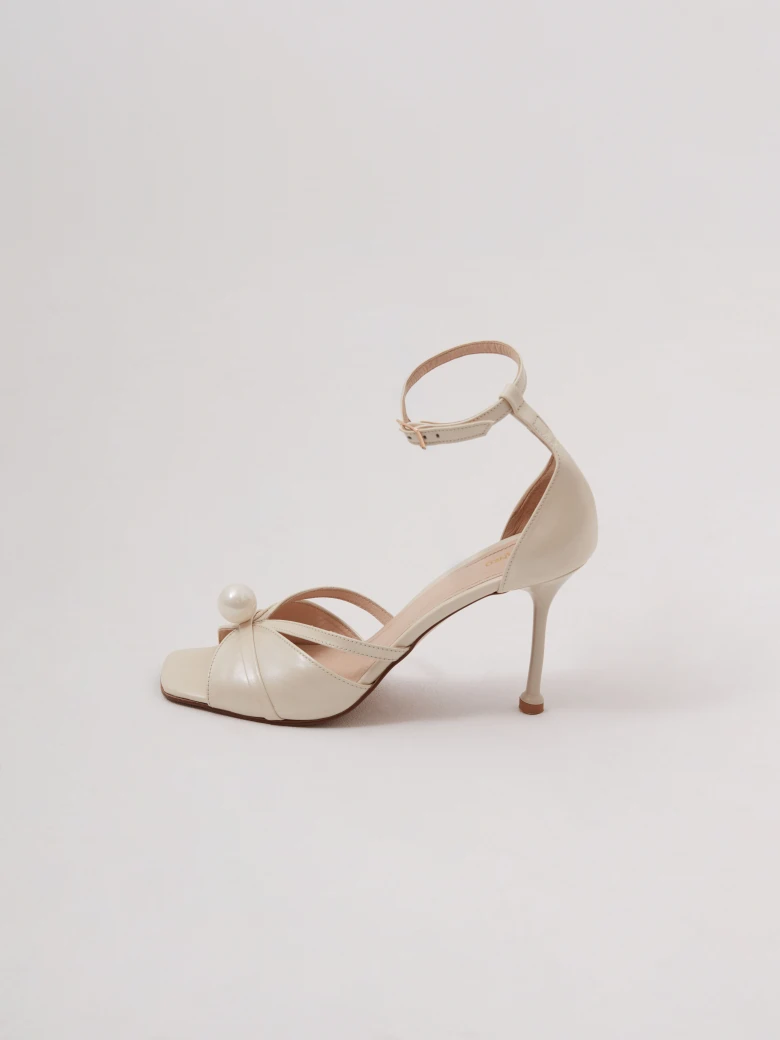 Cream-colored heeled sandals with pearl detailing