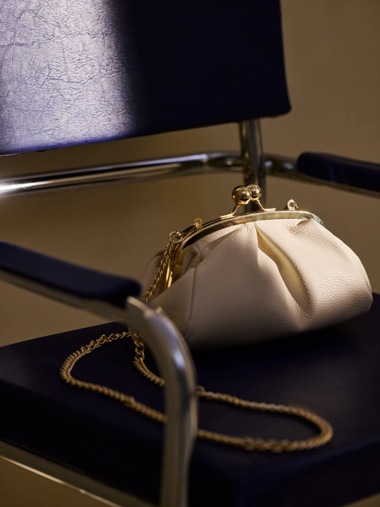 Cream-colored leather handbag with a chain